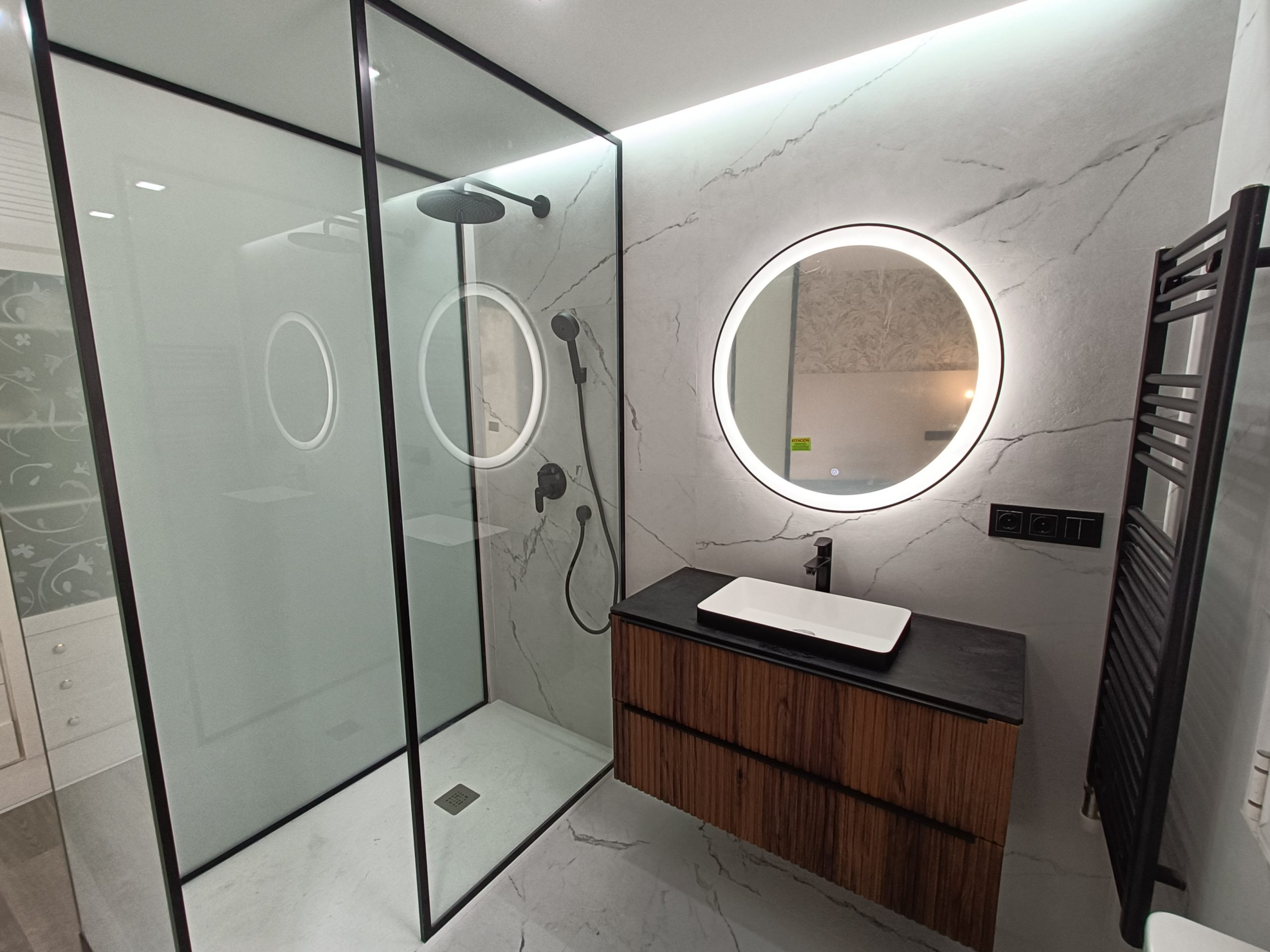 Reforma de baño en Valladolid con alicatado efecto mármol, ducha y espejo con luz LED