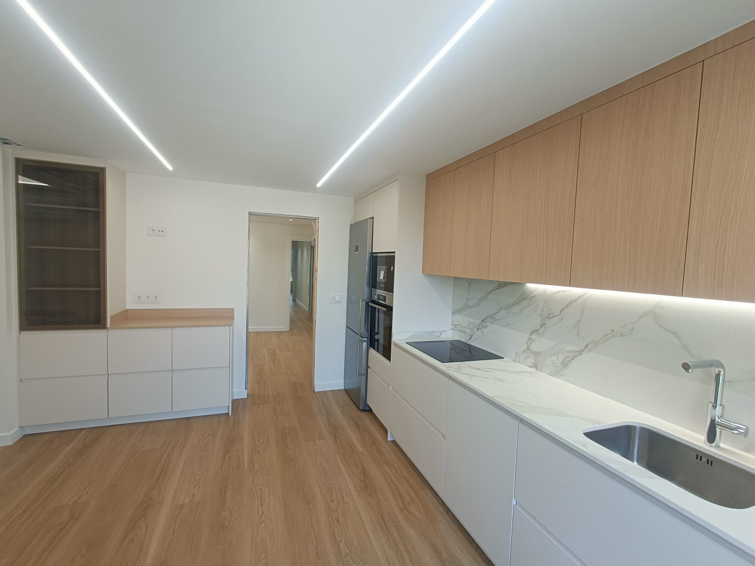 Reforma de cocina a medida en Valladolid con encimera efecto mármol y armarios blancos