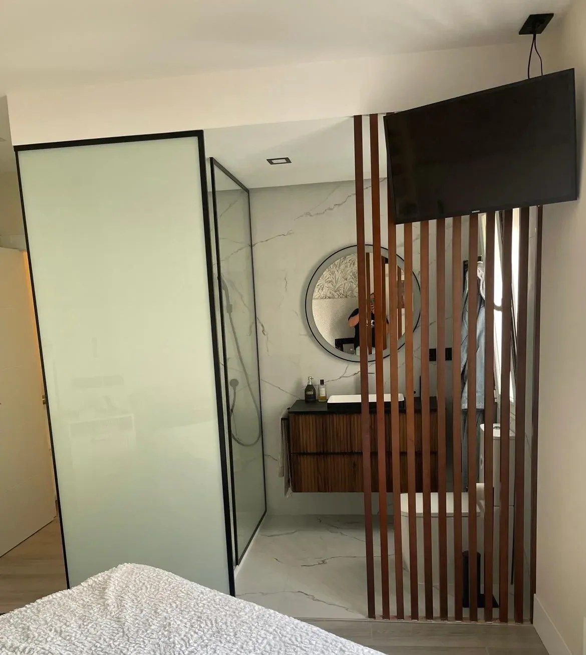 Reforma de baño en suite en Valladolid con mampara, mueble de madera y separación de listones