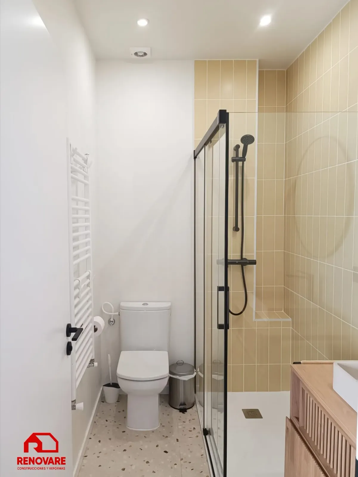 Reforma de baño en Valladolid con ducha, mampara negra y mueble de madera