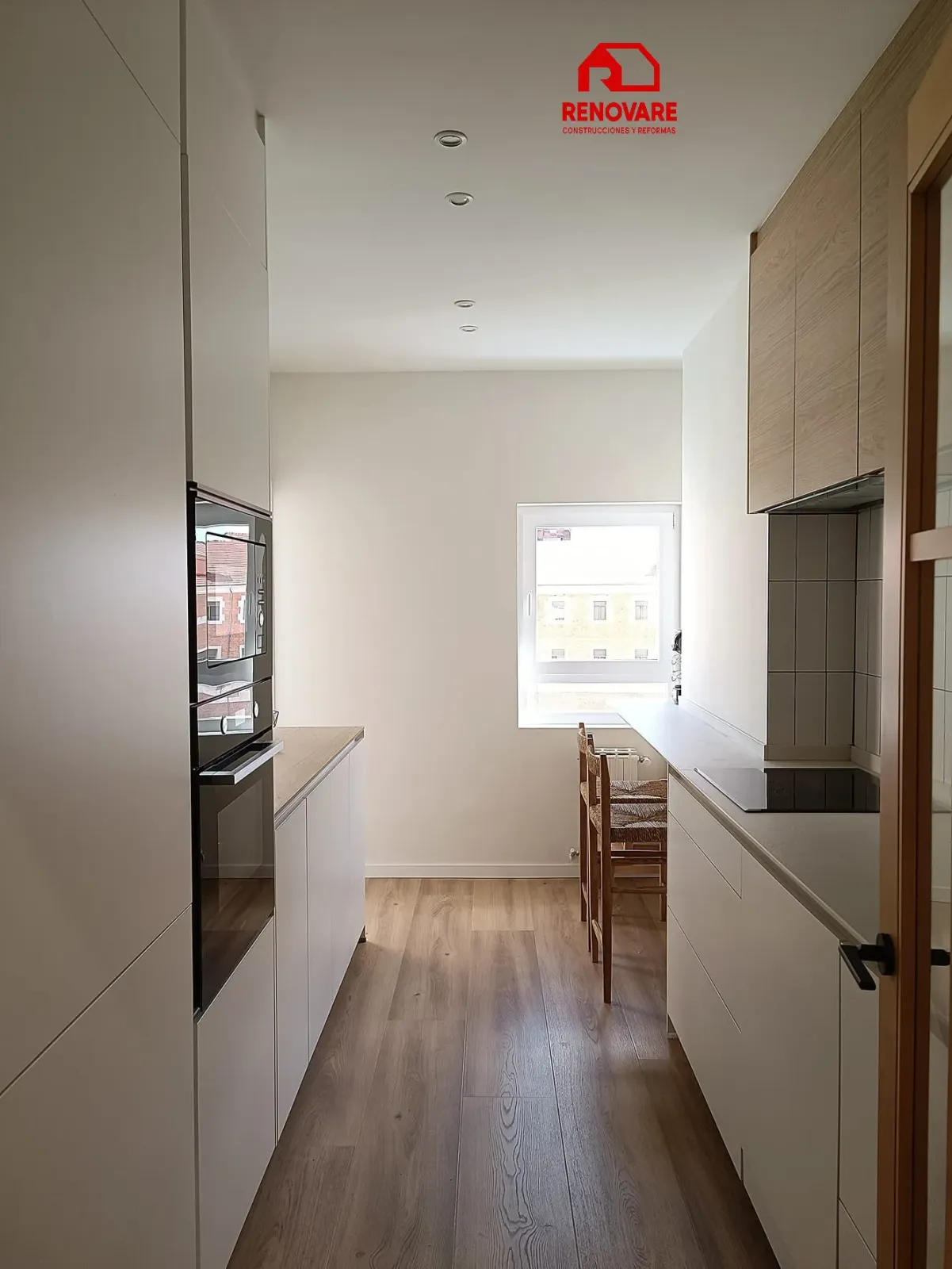 Reforma de cocina en Valladolid con mobiliario blanco, madera y electrodomésticos integrados