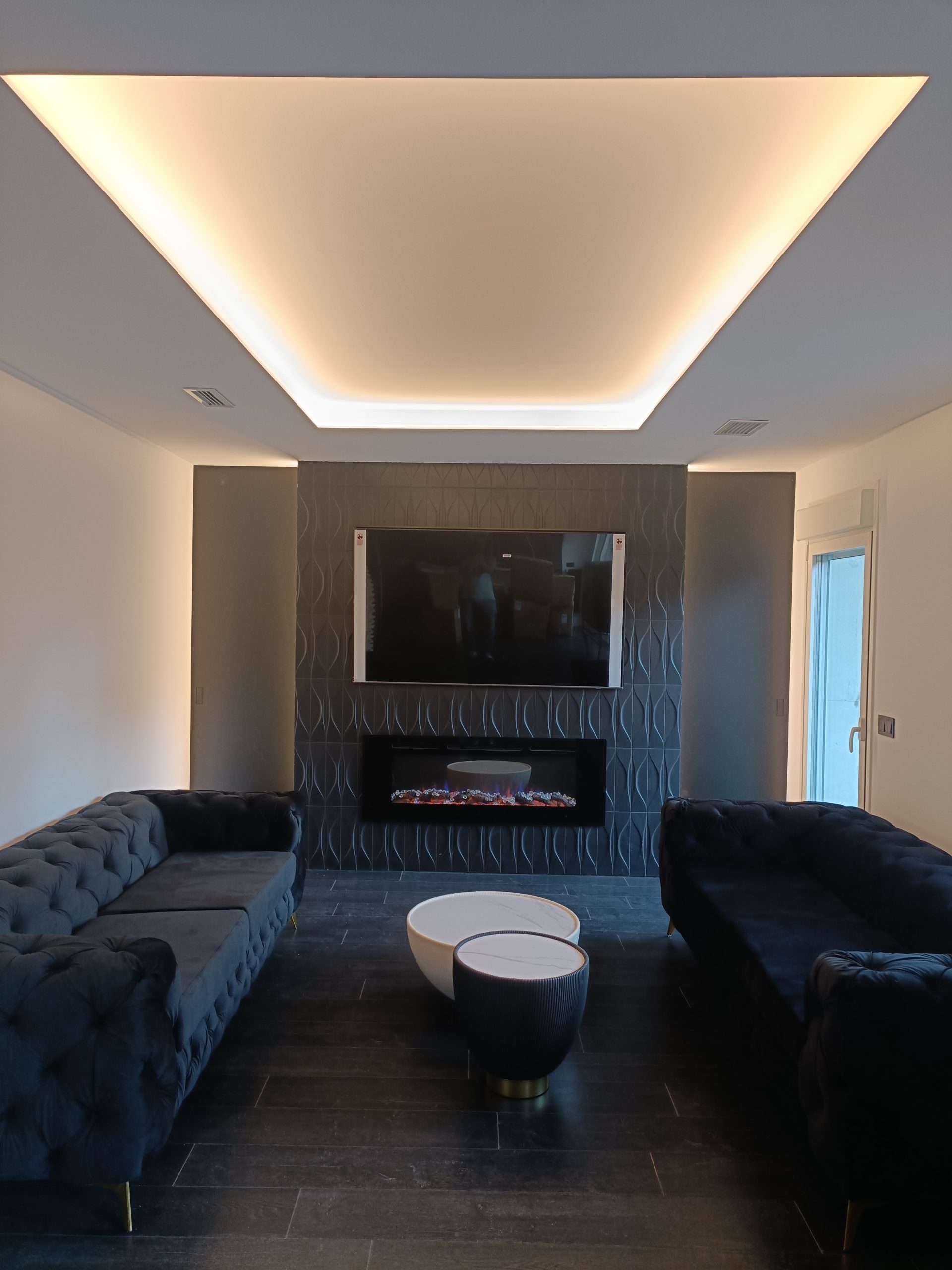 Reforma de salón en Valladolid con pared de TV, chimenea eléctrica e iluminación LED